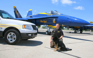 Hero Napór - photo of the dog with officer from K9 police department in the United States in the background of Blue Angel plane